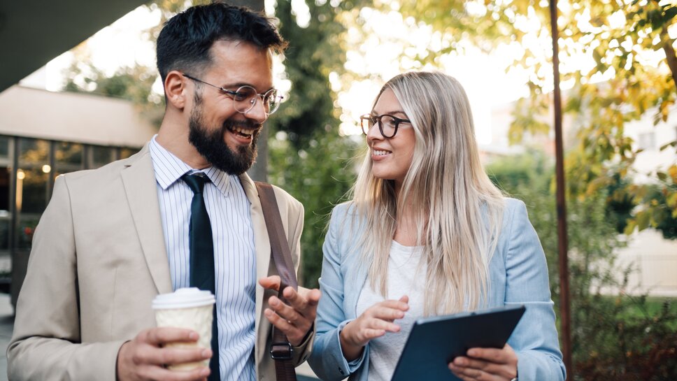 Ein junger Mann im Anzug und eine Frau im Business-Outfit.